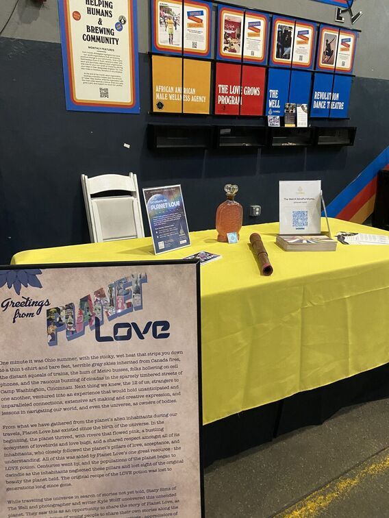 A yellow table with informational flyers about Planet Love
