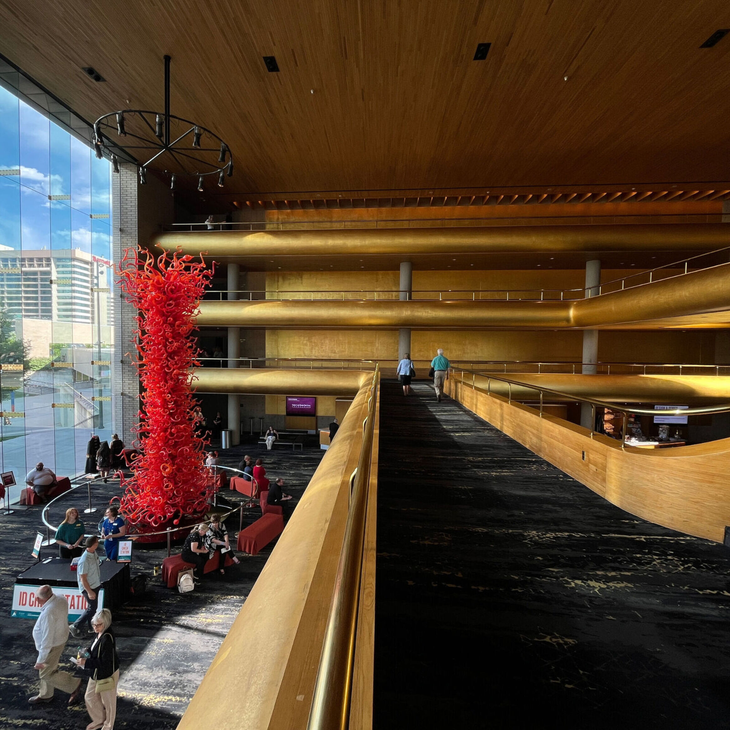 The lobby of Abravanel Hall with gold-leaf walls and a fiery red glass sculpture by Dale Chihuly that rises from the ground floor to the fourth floor.