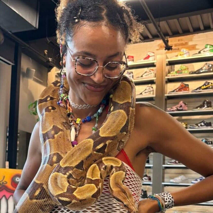 SLiNK love smiles with a large snake around their neck.