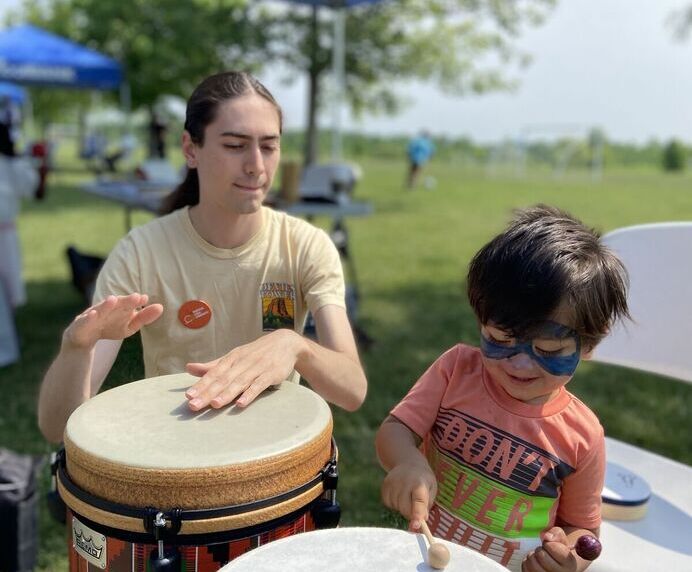 A young man and young boy drumming with their hands